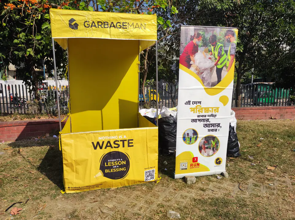 A yellow Garbageman community waste station at an outdoor event